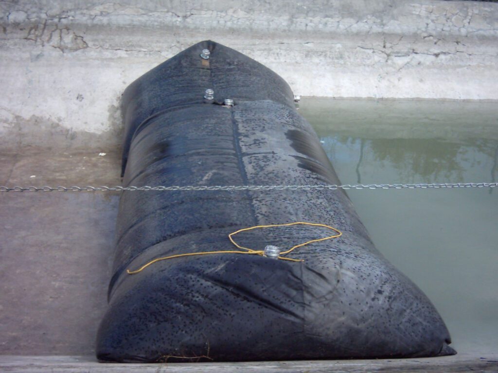 A cofferdam is made from a water-filled bladder to accommodate infrastructure work on a culvert.